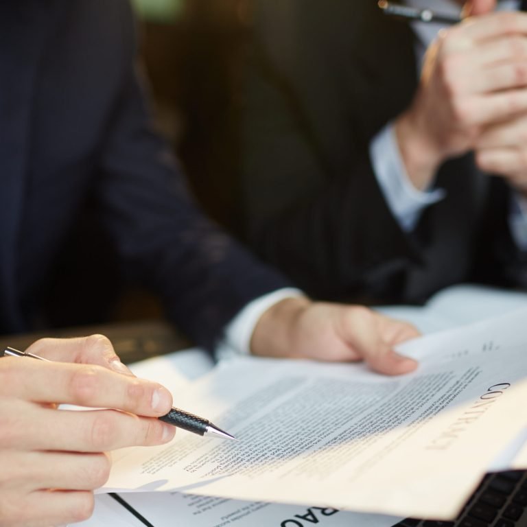 Closeup shot of unrecognizable businessman reading contract documentation at meeting with financial partner